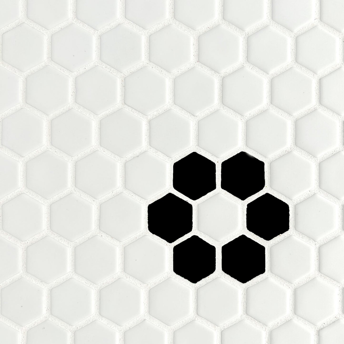 Vintage style white matte mosaic hexagon tiles, with a black rosette pattern in the lower right. Shown installed with white grout.