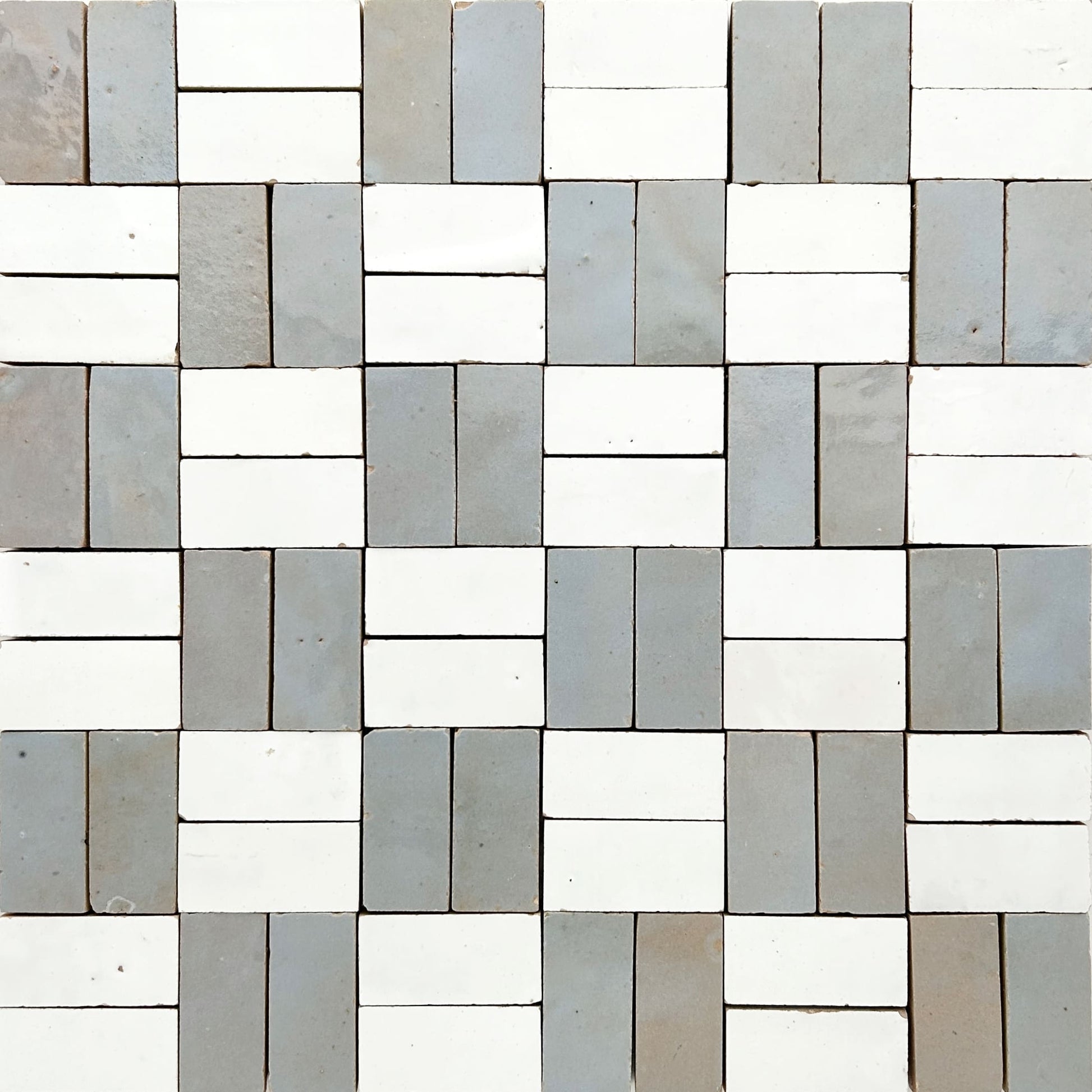 Zellige mosaic tile pattern that is made up of 1x2" pieces, and arranged to give a woven checkerboard feel. The tile colors are a varigated sky blue with hits of green and the natural terracotta color peeking through and white.