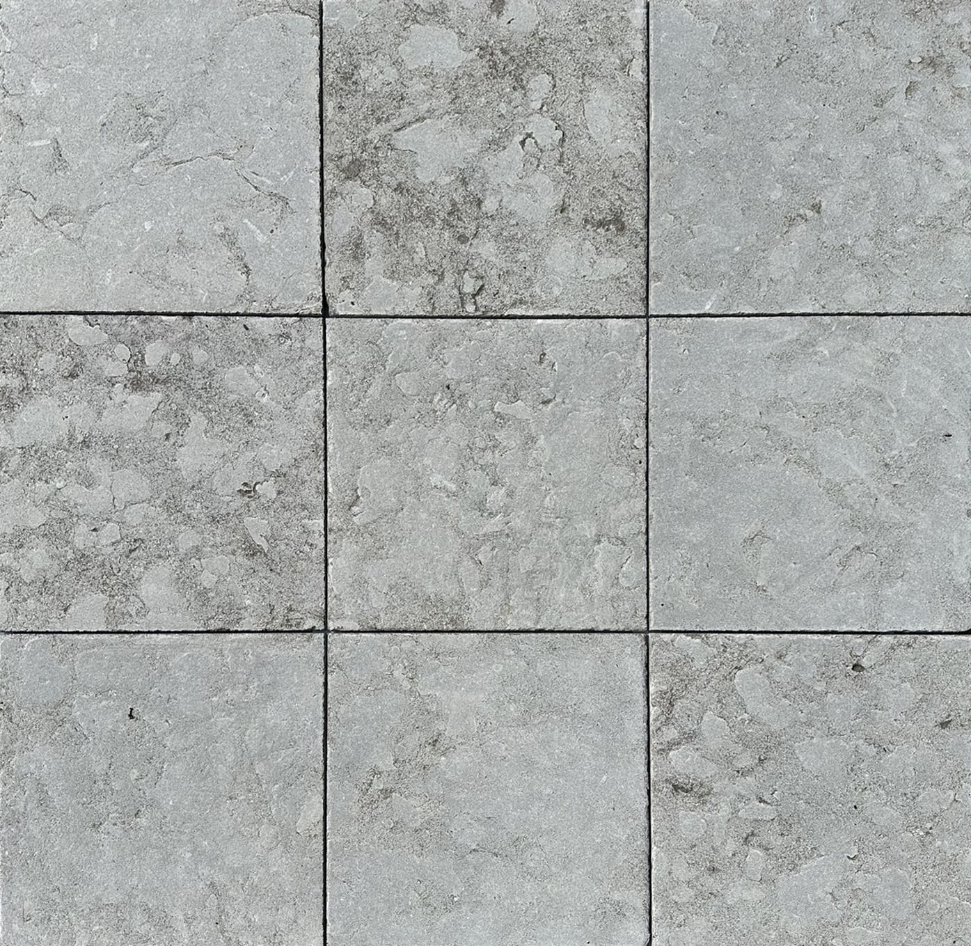 Nine pieces of Lagos Azul tumbled limestone tiles, laid together to show the natural variation of the stone. The stone is a soft gray green color.