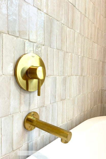 Gold bathroom fixtures on a Casablanca Tusk Zellige tiled wall